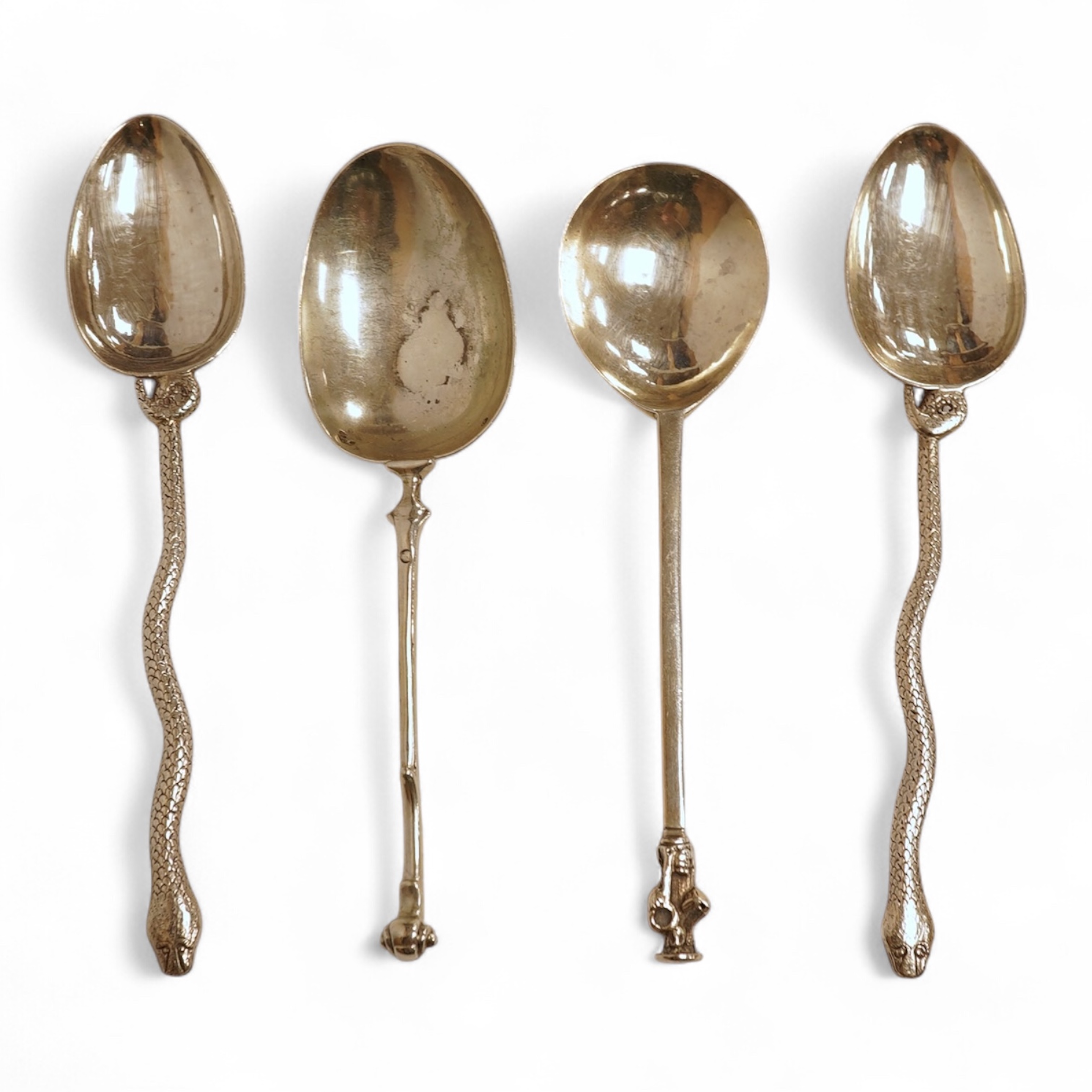 An 18th century silver apostle spoon, indistinct marks, 17cm, a continental white metal spoon with scroll handle and a pair of unmarked white metal spoons with serpent handles.